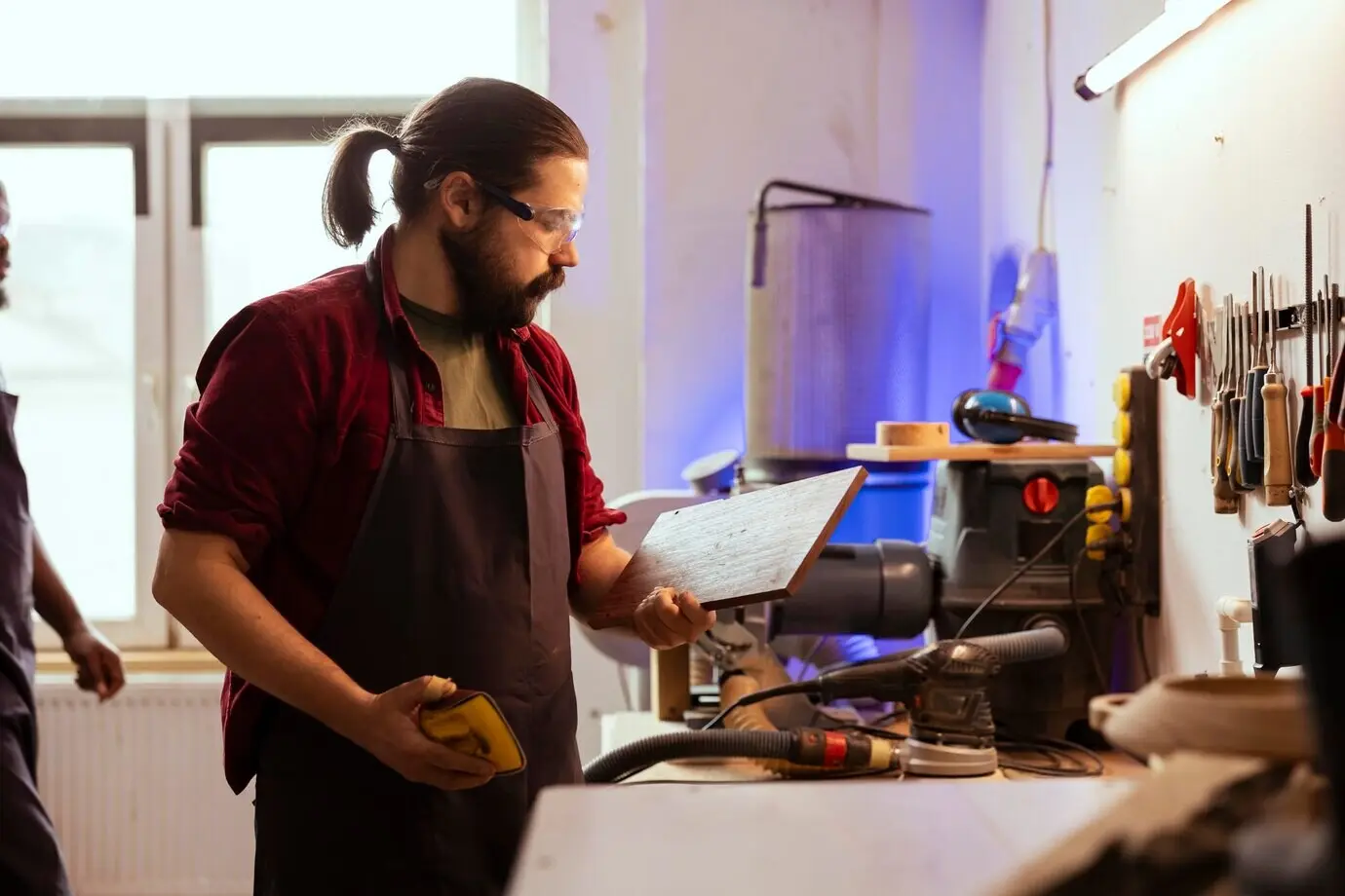 Ein Schreiner gibt einem Holzstück den letzten Schliff, indem er es mit Schleifpapier schleift.