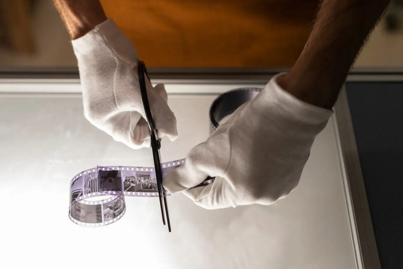 Blick von oben auf einen Mann, der in der Dunkelkammer arbeitet.